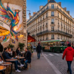 Rue parisienne animée avec le Café de Flore, un marché aux fleurs, la Tour Eiffel en arrière-plan et une fresque colorée d'oiseau.