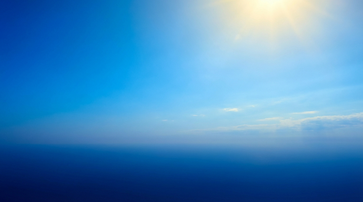 Vaste ciel bleu intense, passant du clair au foncé, avec un soleil éclatant en haut à droite et des rayons de lumière. Horizon flou.